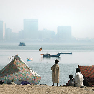 A group of people sitting on the beach
Description automatically generated